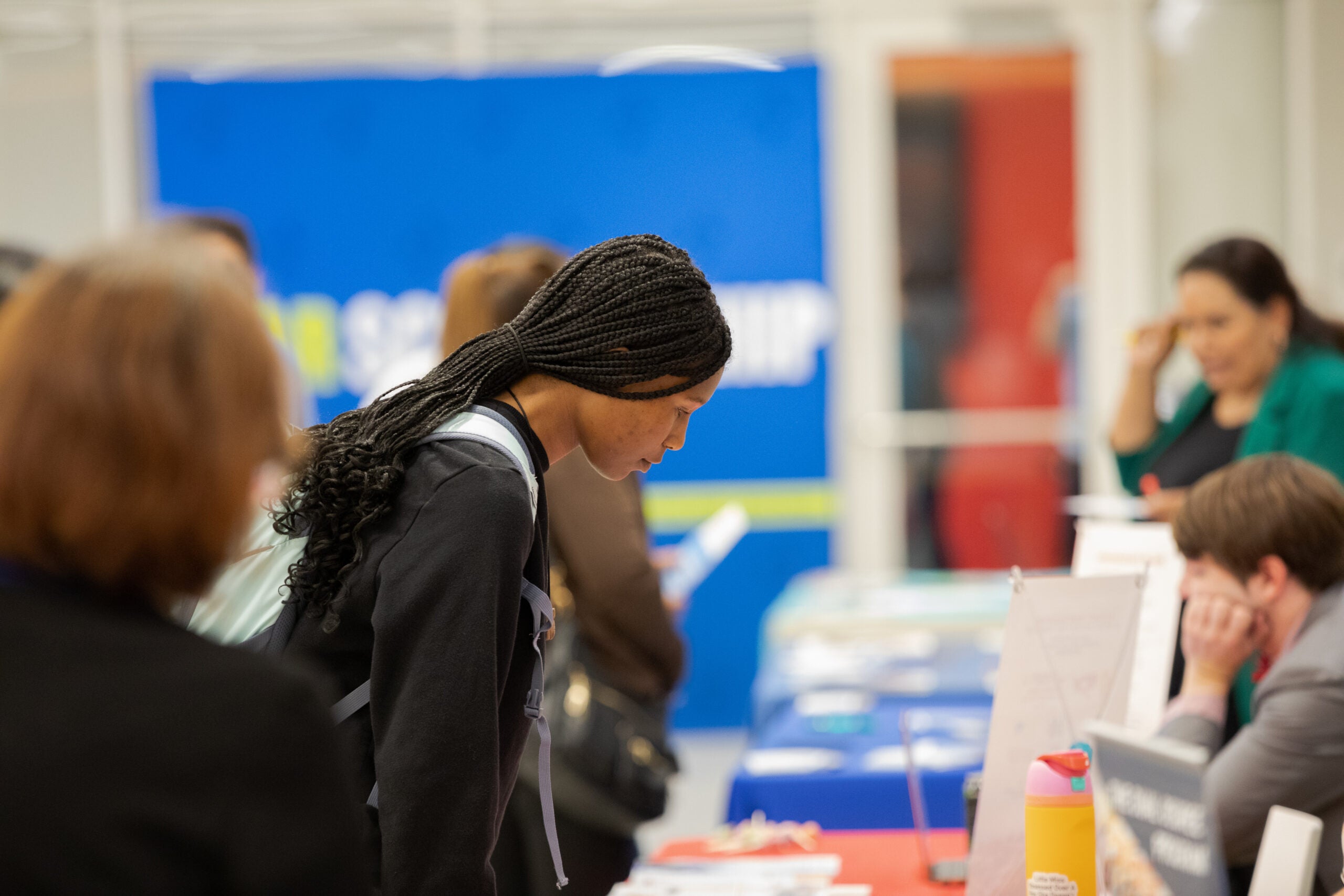 A student learns information from a college at the transfer college fair.
