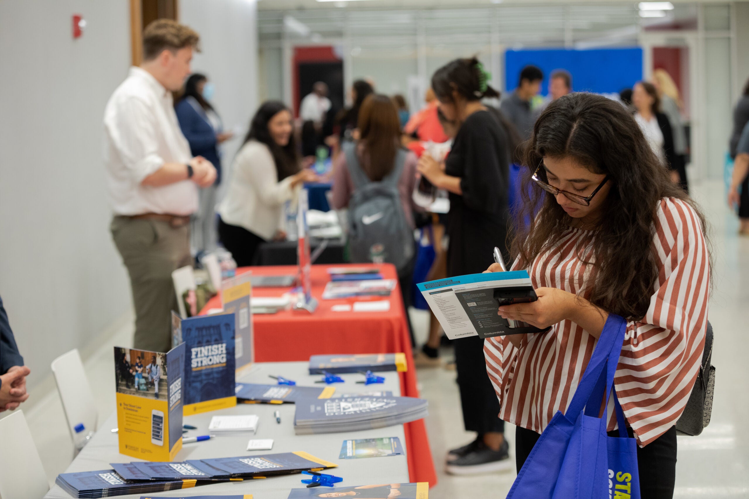 A woman learns information from a college at the transfer college fair.