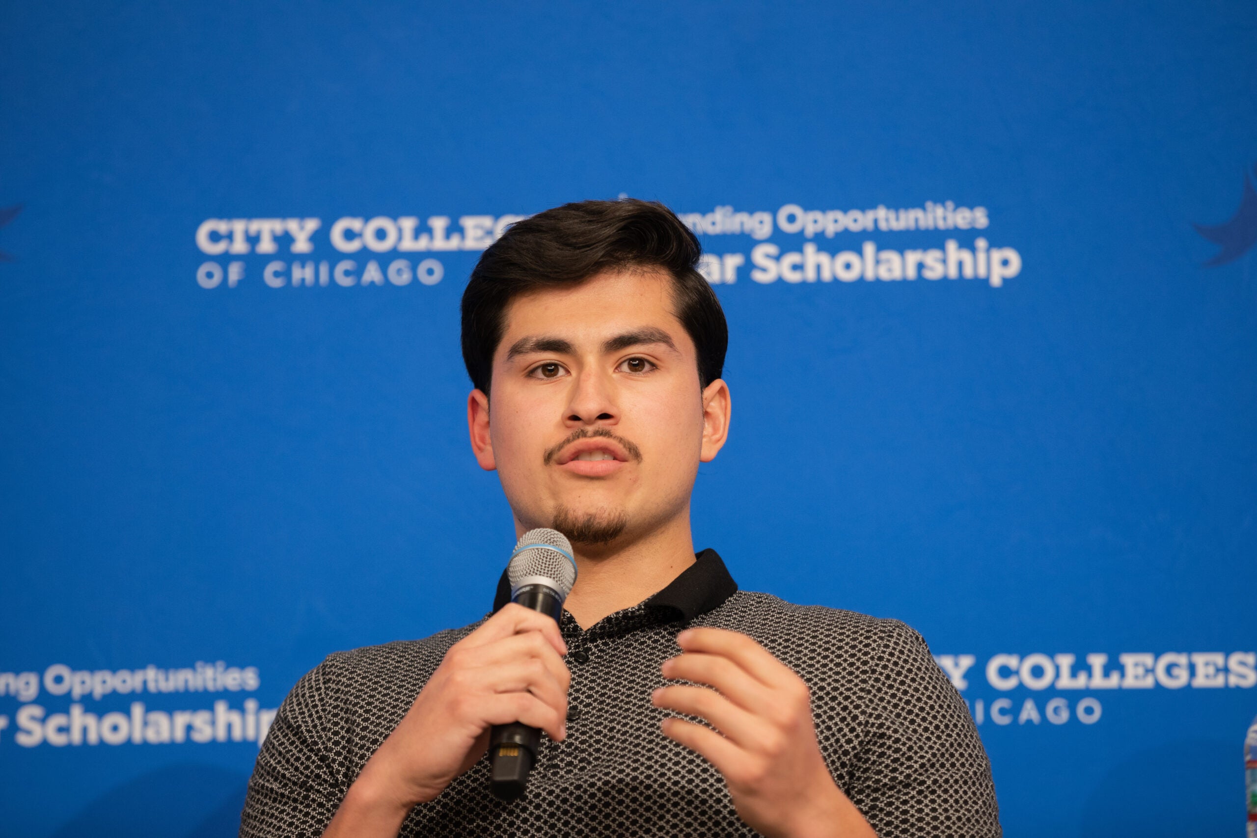 Daley College alumnus Cristian Olivares speaks to the crowd.