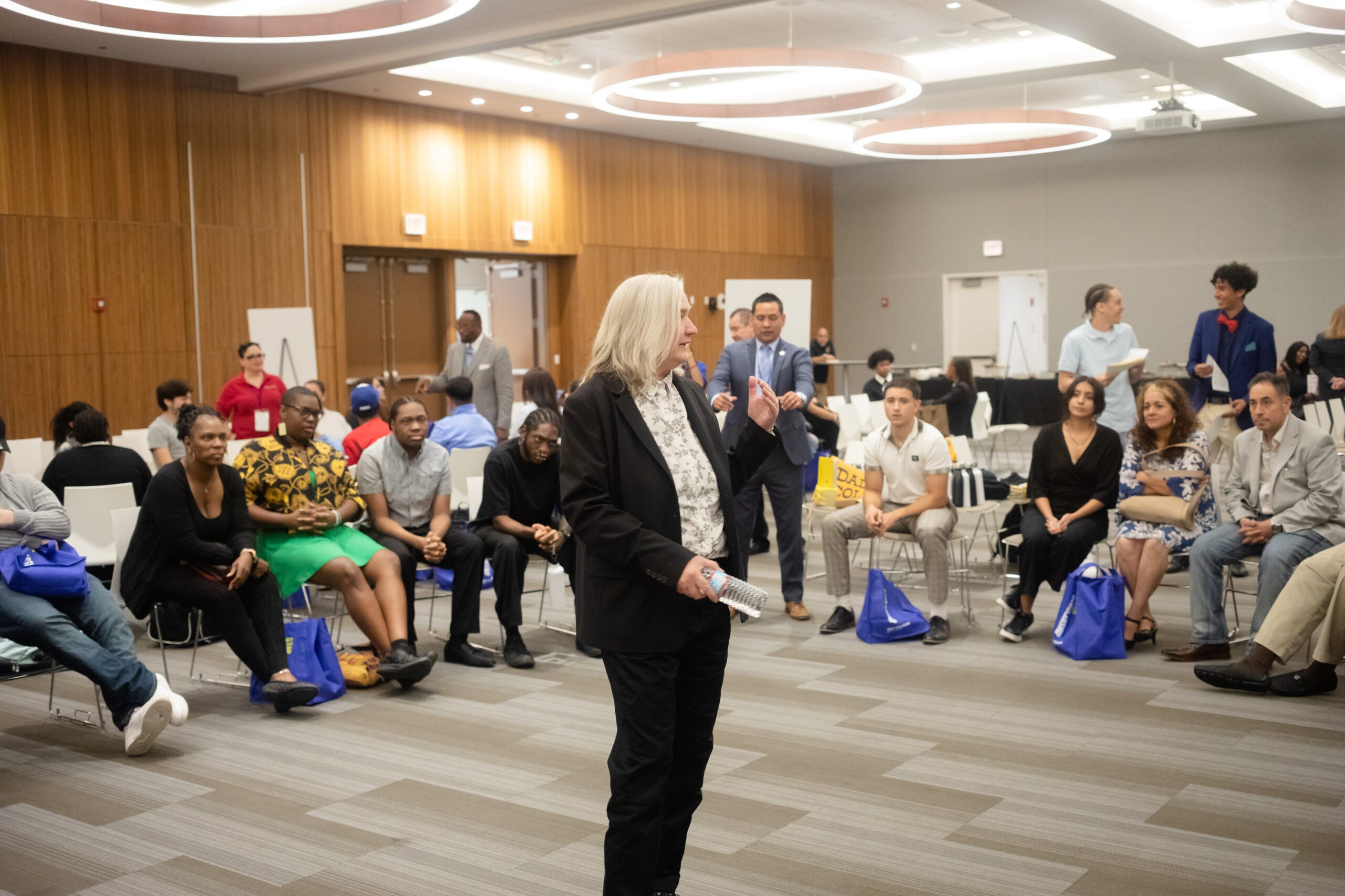President Janosky speaks to a group of students sitting around her.