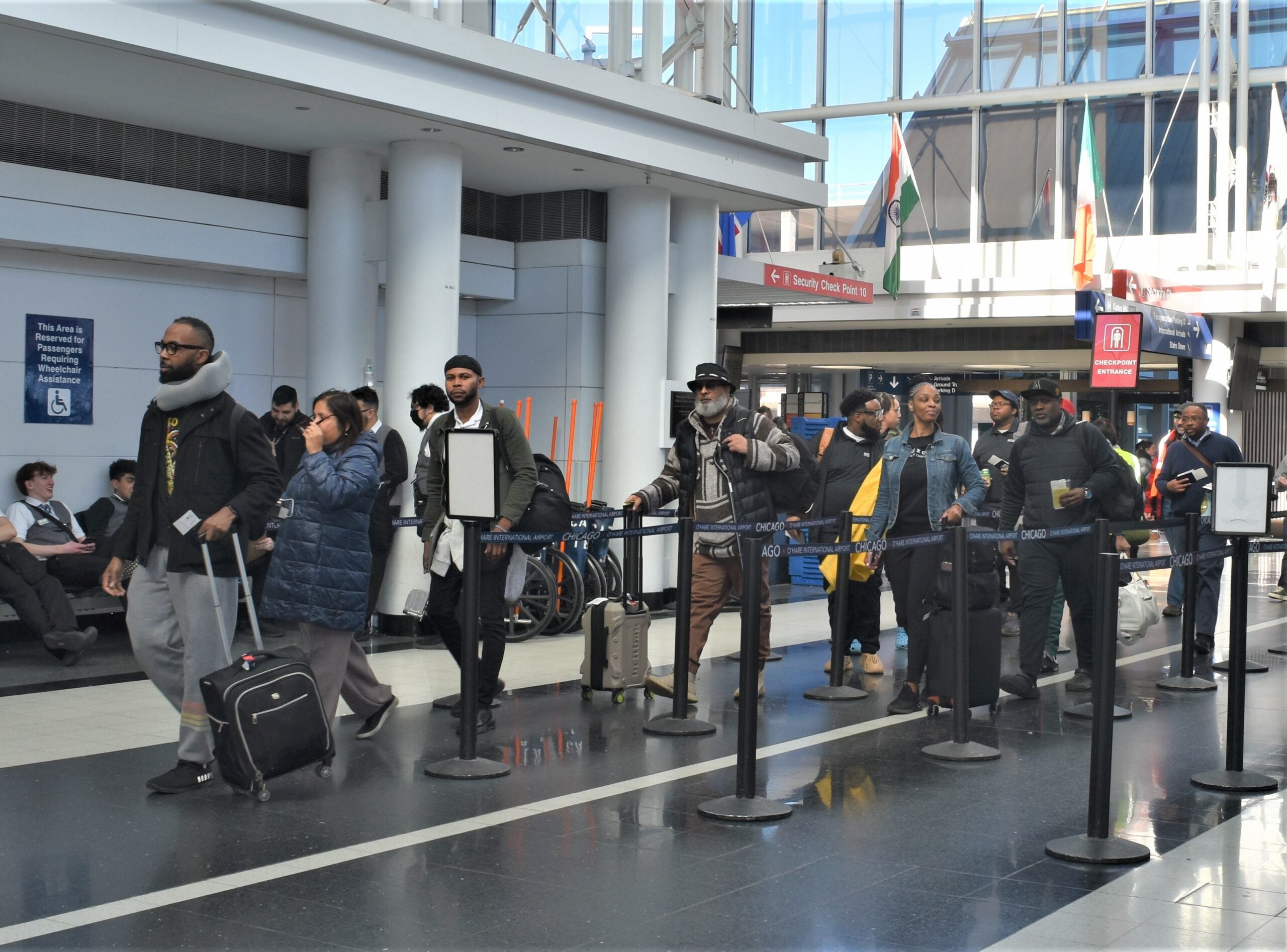 Group of people walks through the airport.