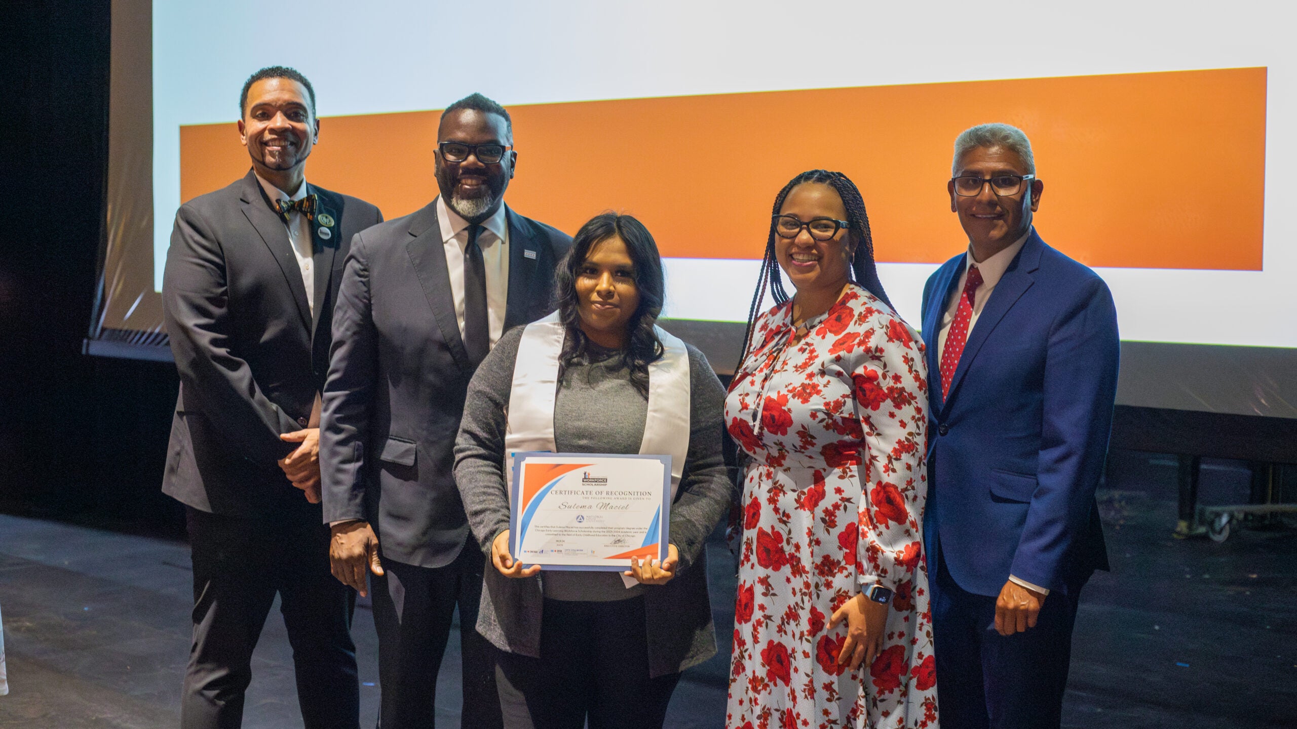 Mayor Brandon Johnson and City Colleges leadership pose with a student for a photo